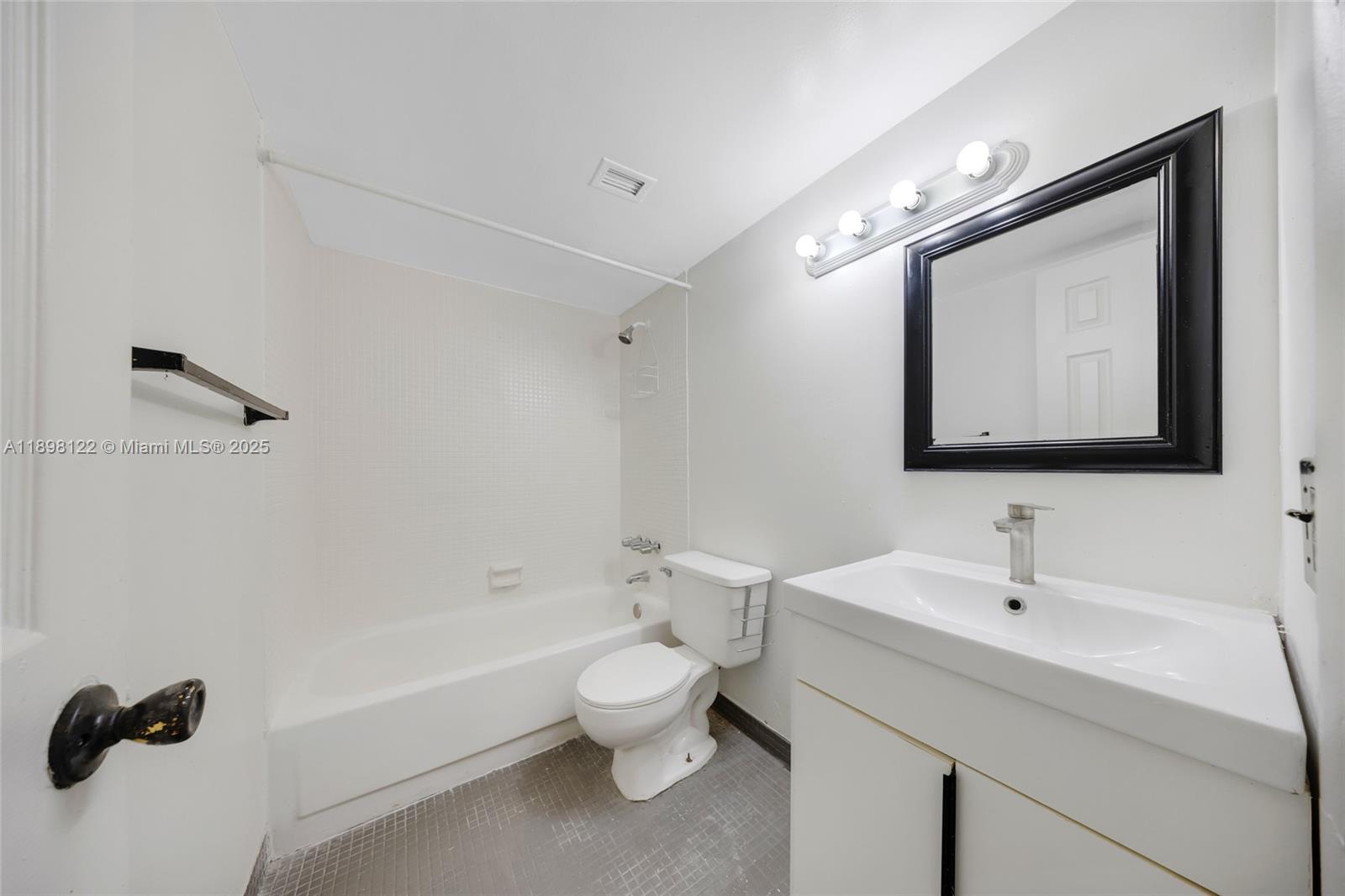 492 Northwest 165th Street, Unit C512 Miami, FL 33169 - Photo 20 of 27 a bathroom with a toilet sink and mirror