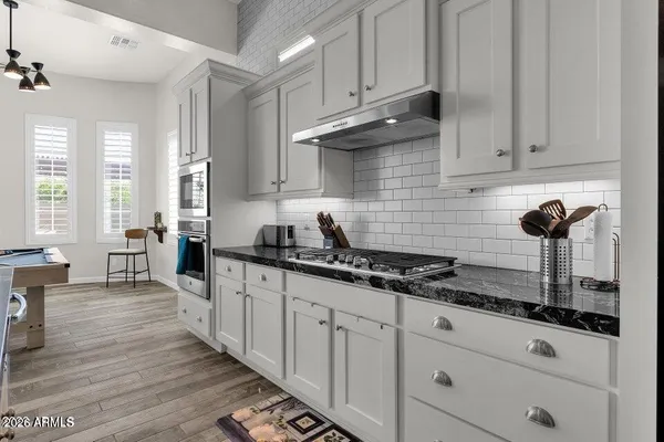 a kitchen with granite countertop a sink a stove and cabinets