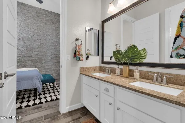 a bathroom with a granite countertop sink a mirror a vanity and a shower