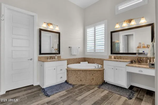 a spacious bathroom with a granite countertop sink mirror and bathtub