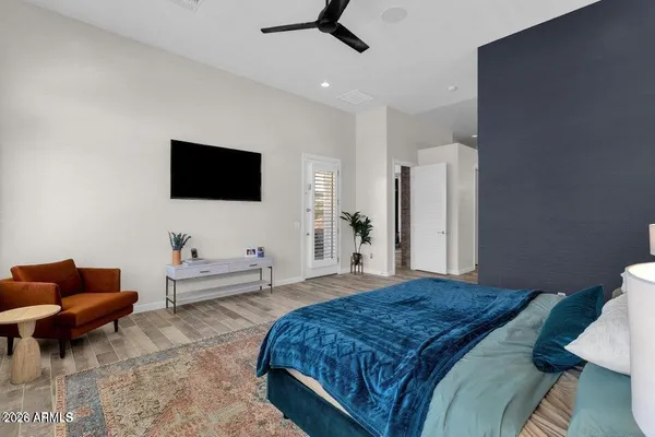 a spacious bedroom with a bed and a flat screen tv