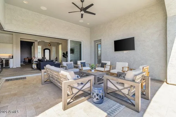 a living room with couches a flat screen tv and a dining table with wooden floor