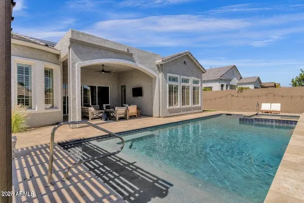 a view of a house with pool and chairs