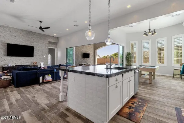 a large kitchen with kitchen island granite countertop a sink counter space and a view of living room
