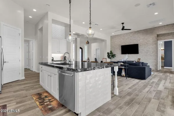 a large kitchen with stainless steel appliances a large counter top a refrigerator and a sink