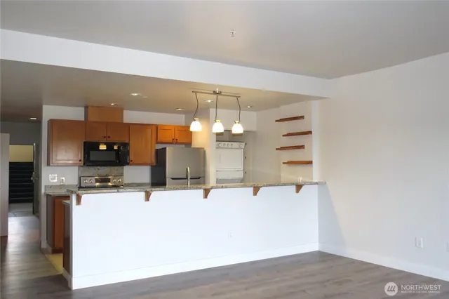 a view of a kitchen with kitchen island a sink and wooden floor