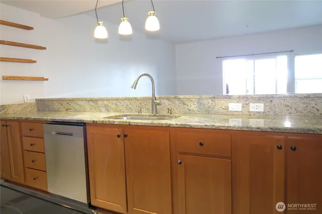 a kitchen with granite countertop white cabinets and stainless steel appliances
