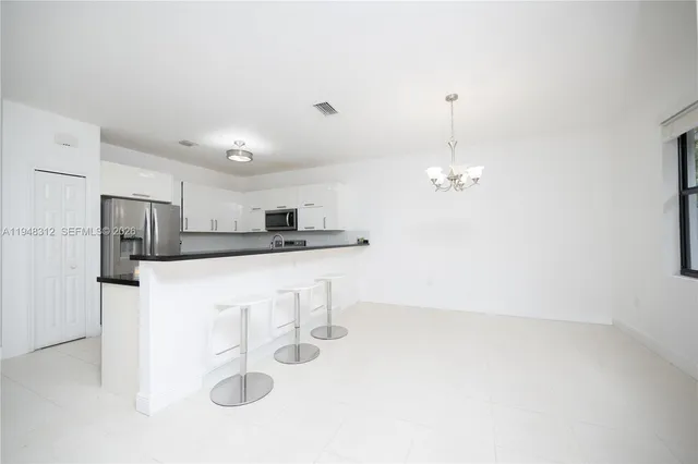 a kitchen with stainless steel appliances granite countertop a refrigerator and a stove top oven
