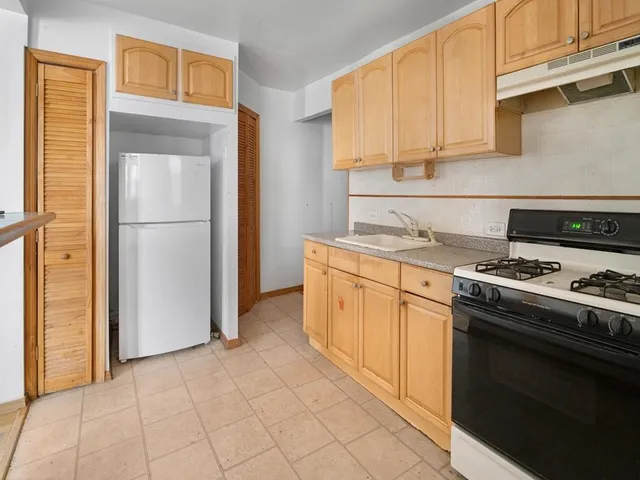 a kitchen with a stove top oven cabinets and a refrigerator