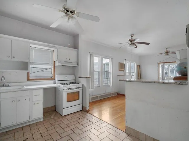 a kitchen with a stove sink and cabinets