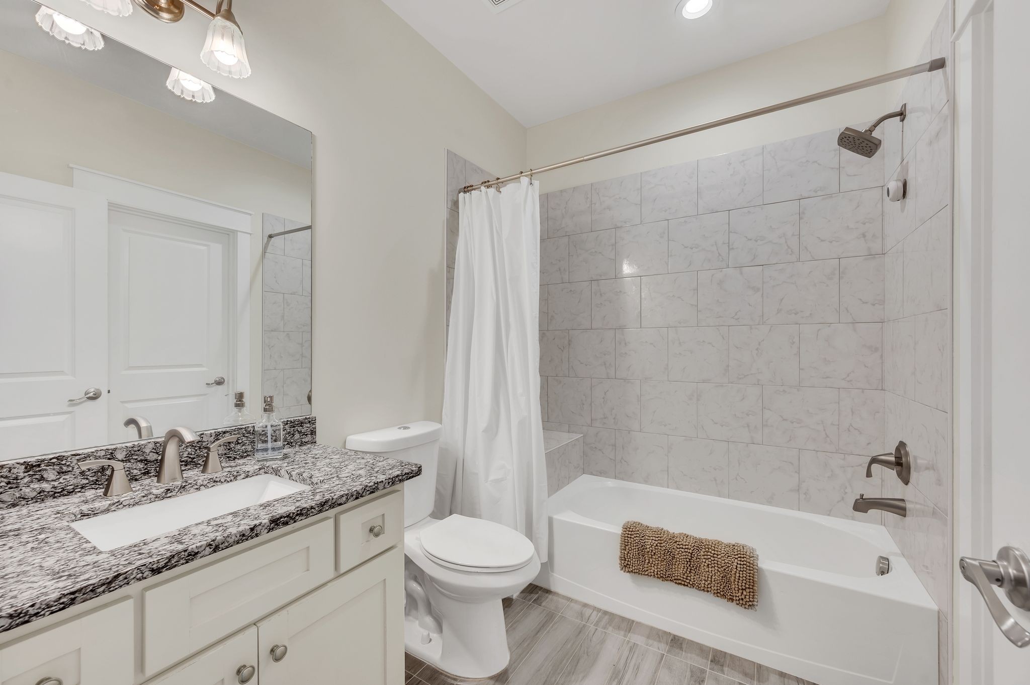2156 Hartland Road Franklin, TN 37069 - Photo 43 of 63 a bathroom with a granite countertop sink a toilet a mirror and shower