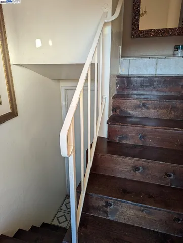 a view of a hallway with wooden floor and stairs
