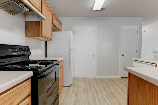 a kitchen with granite countertop cabinets stainless steel appliances and wooden floor