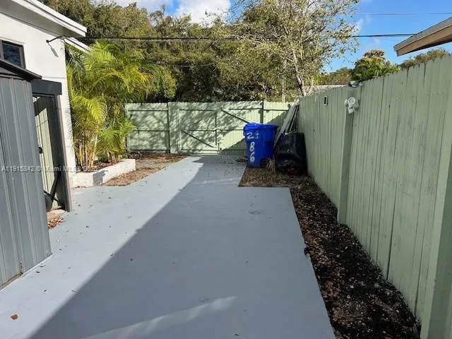a view of a yard with wooden fence