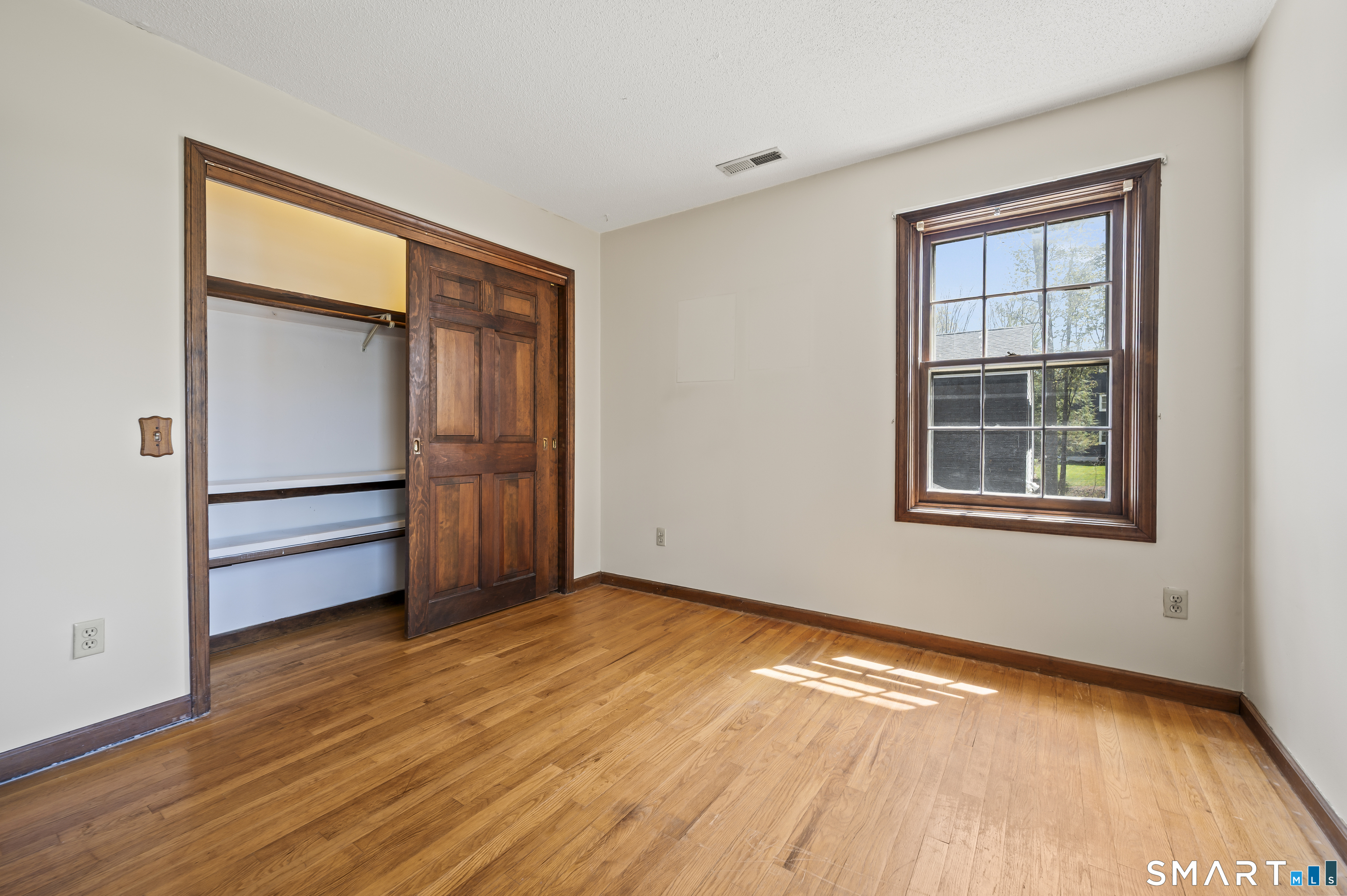 117 Charter Oak Road Southbury, CT 06488 - Photo 33 of 40 a view of an empty room with a window and wooden floor