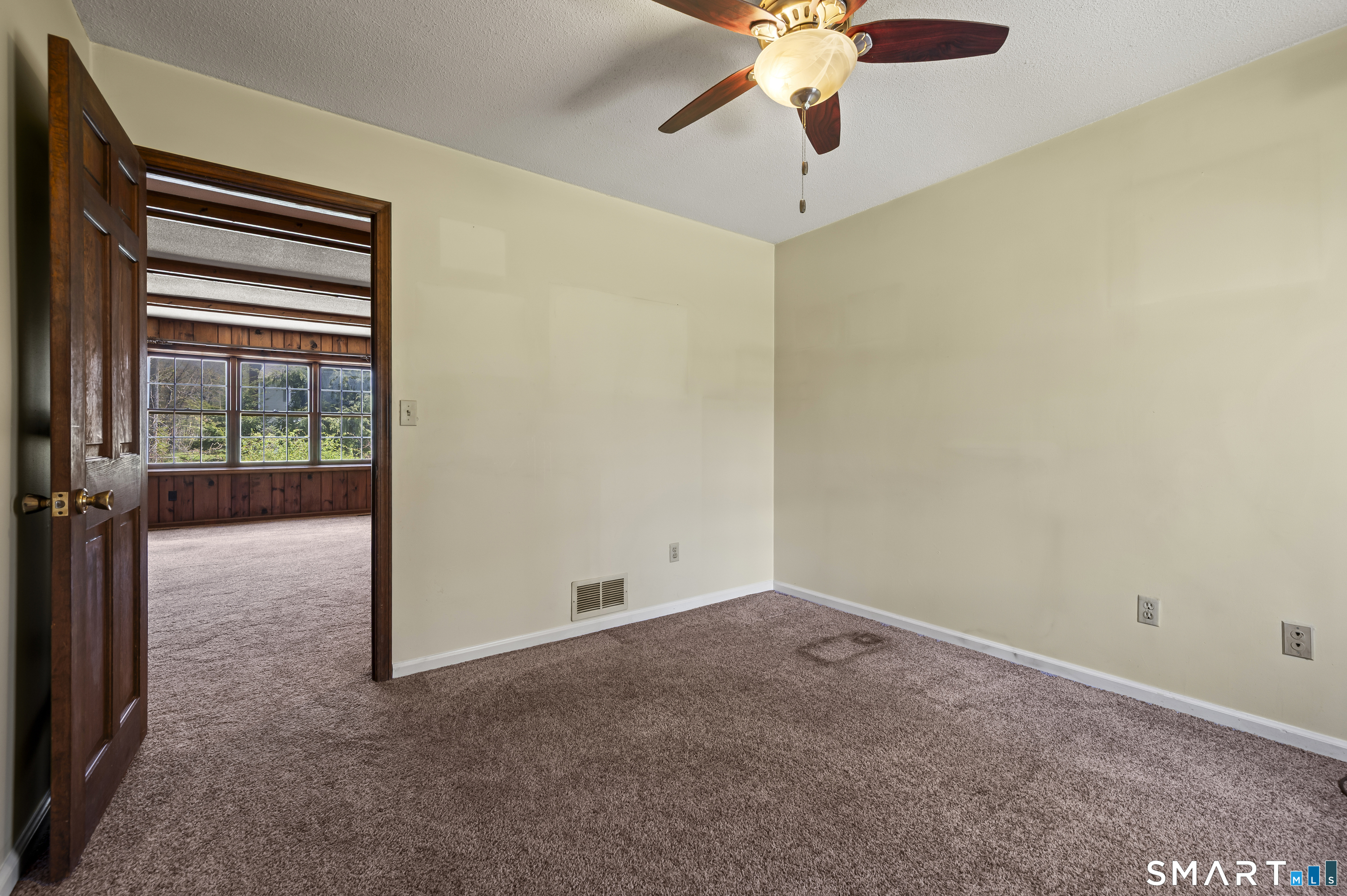 117 Charter Oak Road Southbury, CT 06488 - Photo 10 of 40 an empty room with a chandelier fan and windows