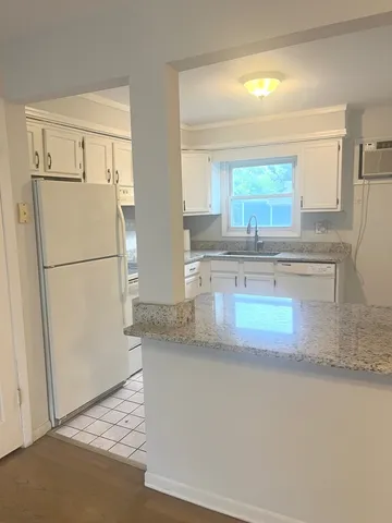 a kitchen with granite countertop a refrigerator a sink and a stove