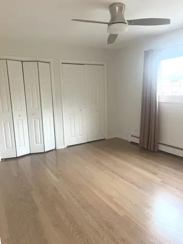 an empty room with fan & windows