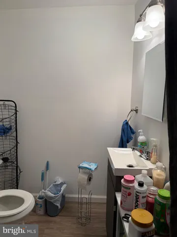 a view of a hallway with toilet and door with a mirror