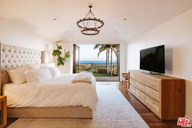 a spacious bedroom with a bed and a flat screen tv