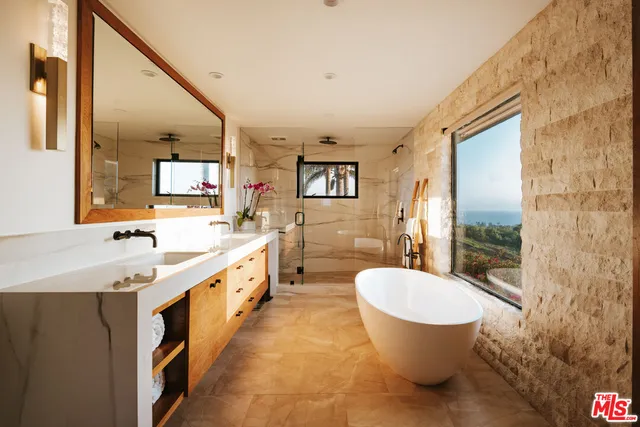 a spacious bathroom with a granite countertop sink and a large mirror