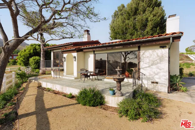 a view of a house with backyard and sitting area