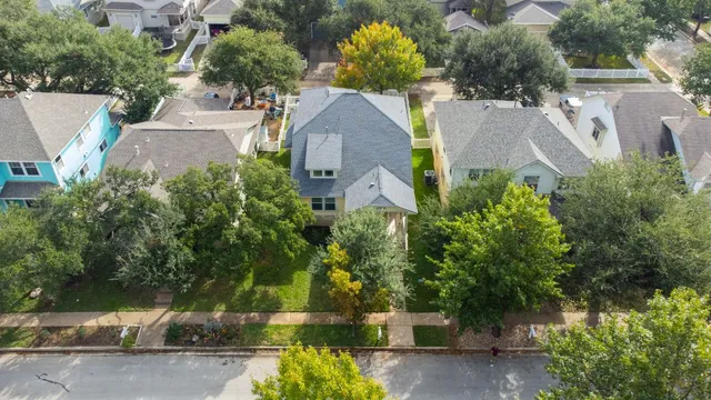 an aerial view of a house with a yard and a large tree
