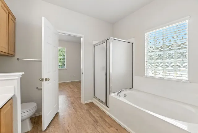 an empty room with windows and ceiling fan