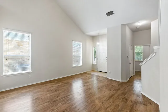 a view of an empty room with wooden floor