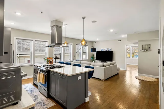 a large kitchen with stainless steel appliances kitchen island granite countertop a sink and a stove