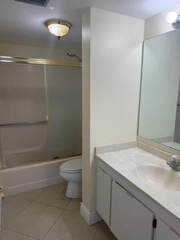 21911 Lake Forest Circle, Unit 201 Boca Raton, FL 33433 - Photo 4 of 8 a bathroom with a granite countertop sink a toilet and shower