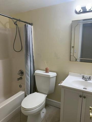 21911 Lake Forest Circle, Unit 201 Boca Raton, FL 33433 - Photo 7 of 8 a bathroom with a toilet sink vanity and shower