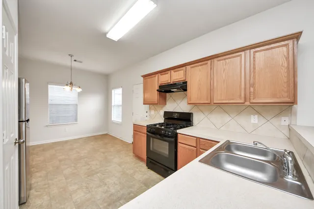 a kitchen with granite countertop a sink stainless steel appliances and cabinets