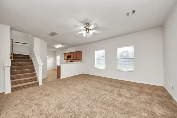 an empty room with windows and fan
