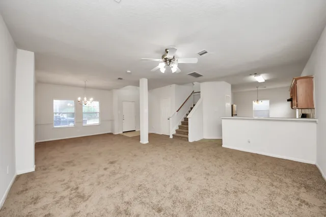 an empty room with a ceiling fan and window
