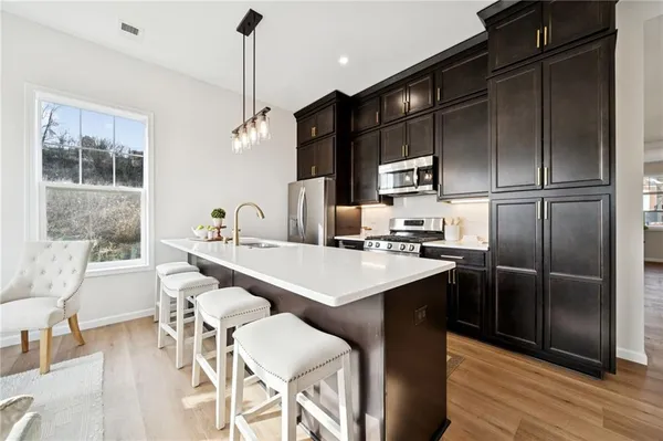 a kitchen with stainless steel appliances granite countertop a sink refrigerator and cabinets