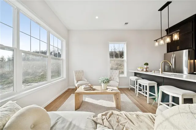 a living room with furniture a flat screen tv and a large window
