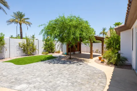 a view of a house with a backyard and a tree