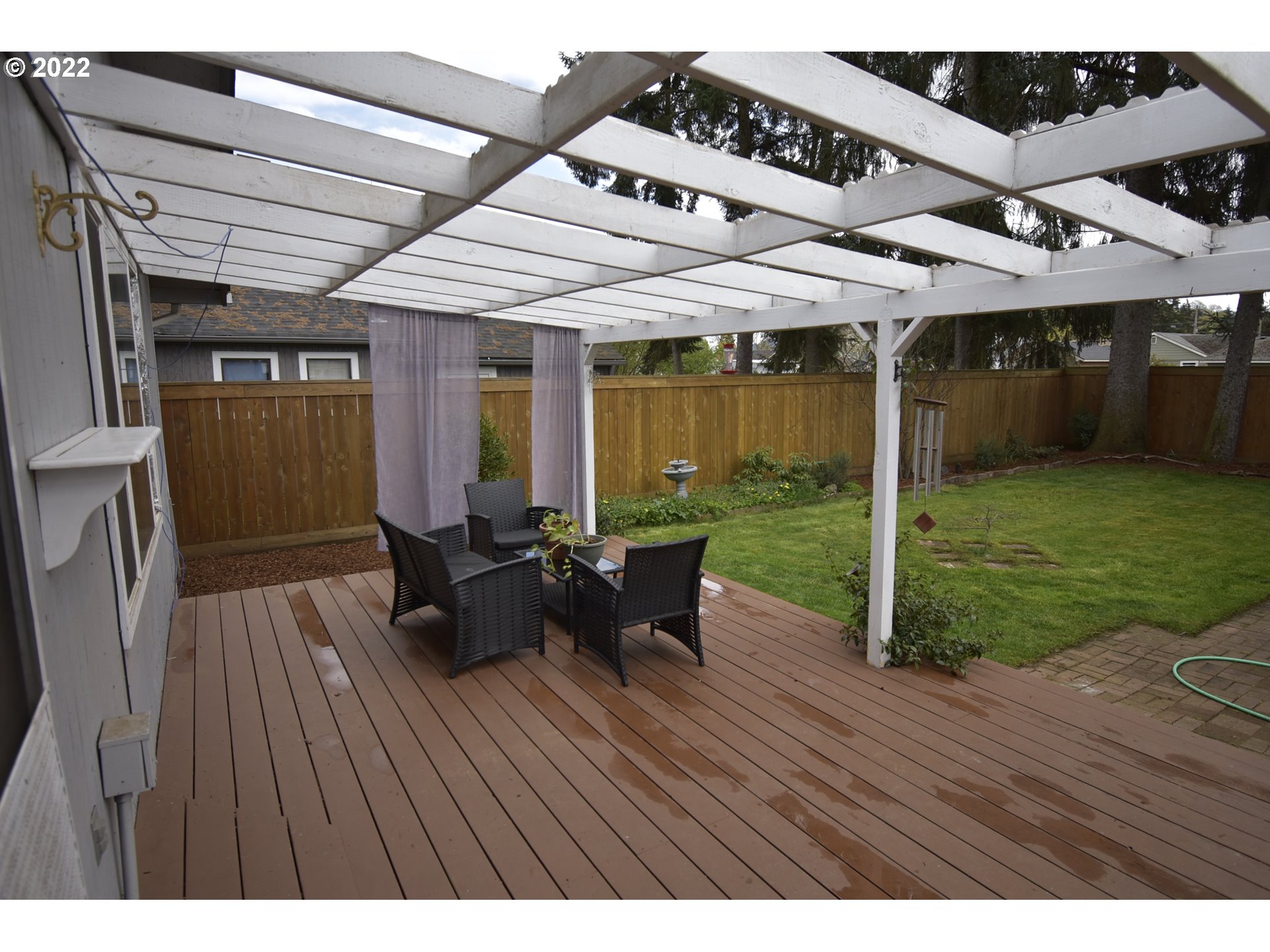 717 Night Hawk Lane Springfield, OR 97477 - Photo 13 of 32 a view of a patio with table and chairs with wooden floor and fence