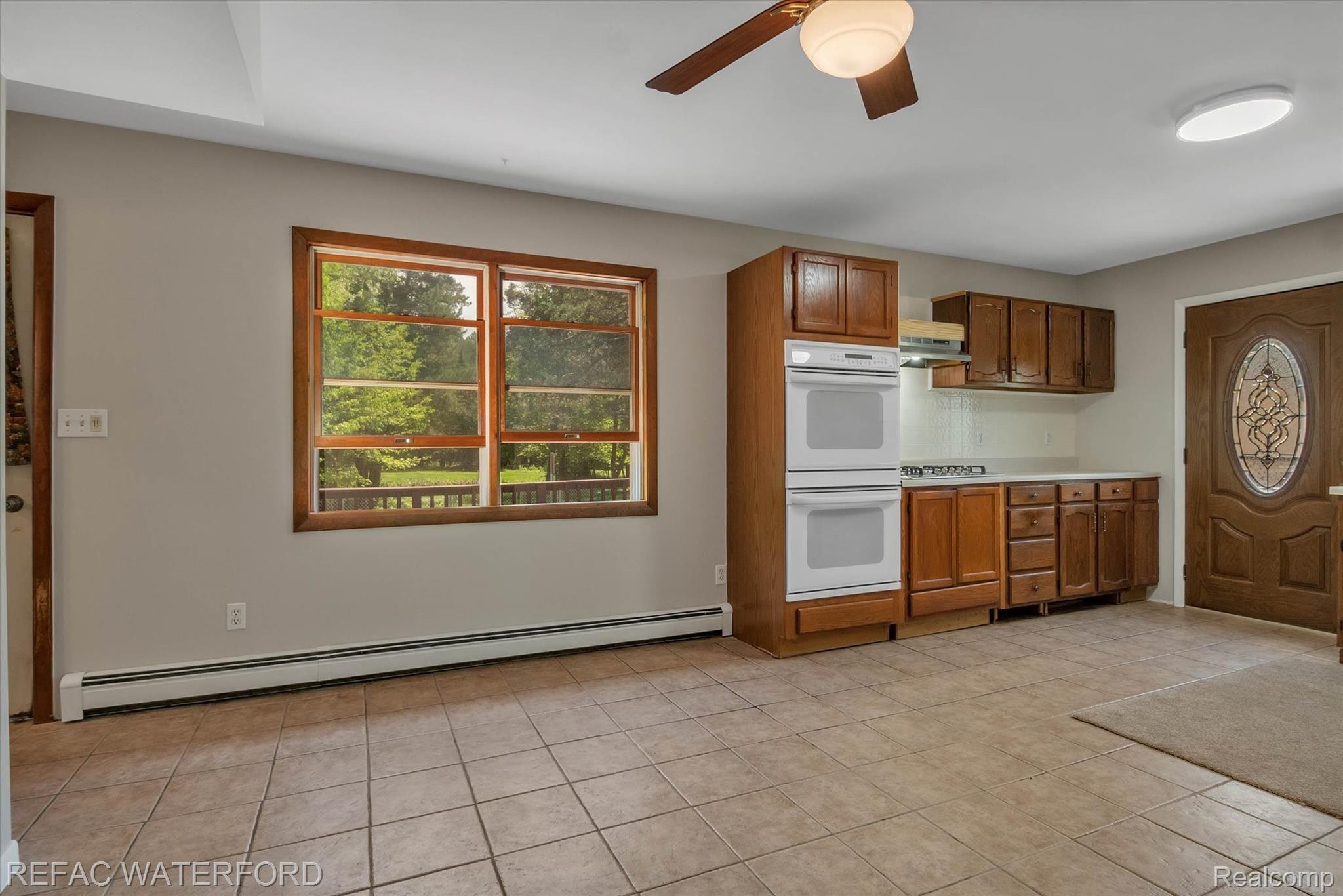 480 Roscommon Road Roscommon, MI 48653 - Photo 12 of 65 Kitchen view from living area - lots of windows in this home for airflow, double wall oven, new gas cooktop. Door to driveway entrance.