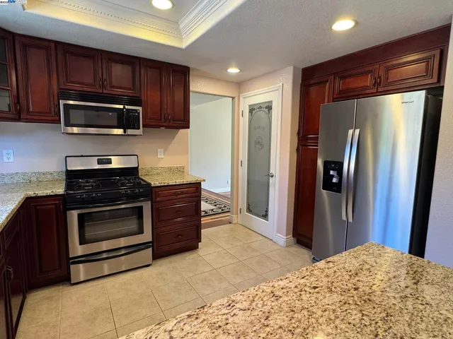 a kitchen with stainless steel appliances granite countertop a stove sink and cabinets