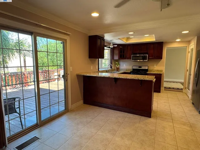 a kitchen with granite countertop a stove top oven a sink a refrigerator and a granite counter tops