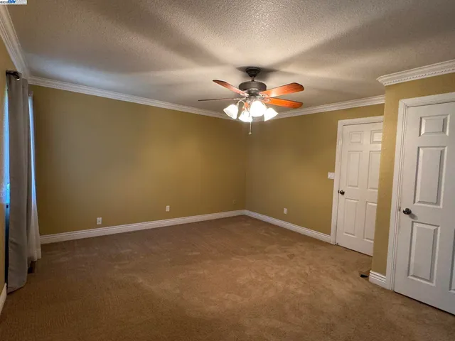 an empty room with a fan and a fan