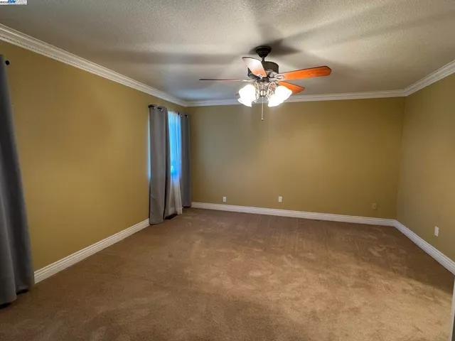 a view of an empty room with a ceiling fan