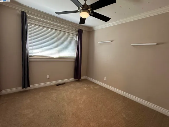 an empty room with closet and a ceiling fan
