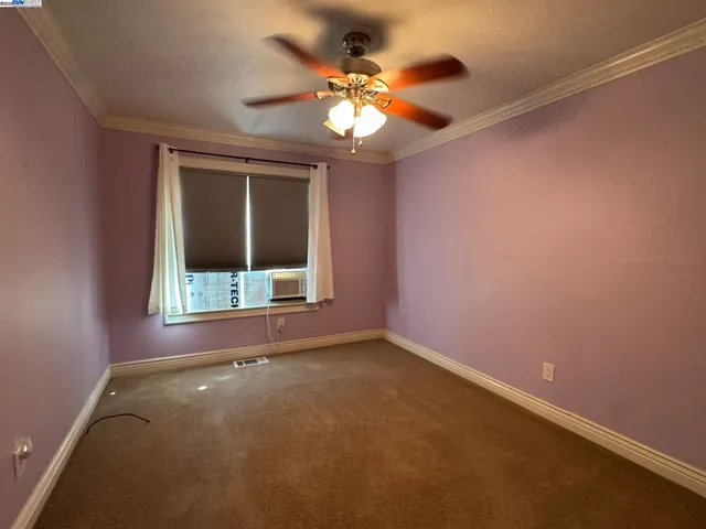 an empty room with a chandelier fan and a chandelier fan