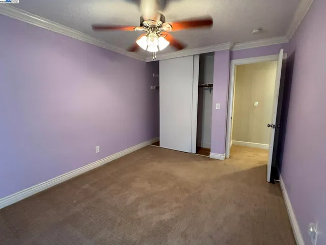 a view of an empty room with a ceiling fan
