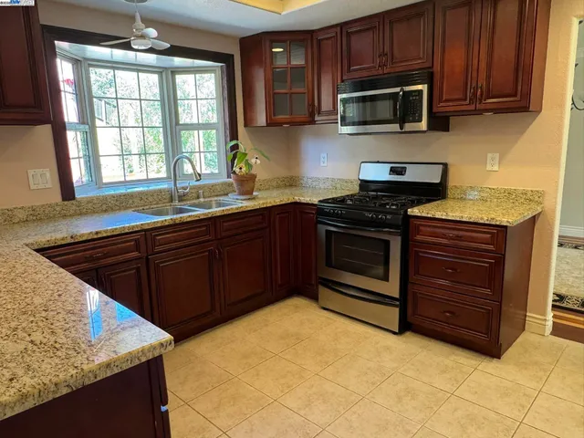 a kitchen with stainless steel appliances granite countertop a refrigerator and a stove top oven