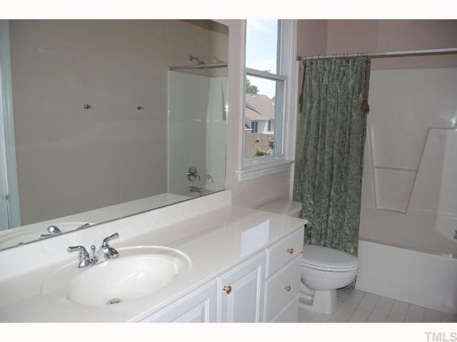 The master bath has a large marble vanity, tile floors, and hosts a laundry closet with a stackable washer/dryer.