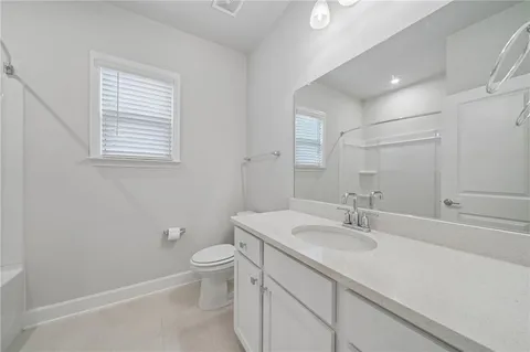 a bathroom with a sink a toilet and a large mirror